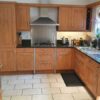 Tan kitchen with thick granite & appliances