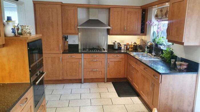 Tan kitchen with thick granite & appliances