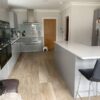 Beautiful Hacker Pearl Grey Gloss Handleless Kitchen with Composite Stone Worktops