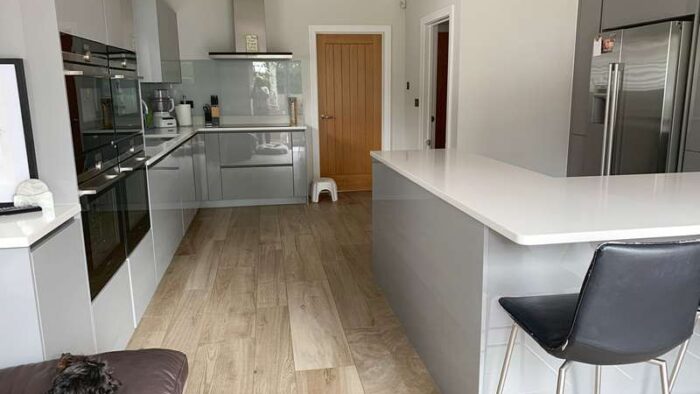 Beautiful Hacker Pearl Grey Gloss Handleless Kitchen with Composite Stone Worktops