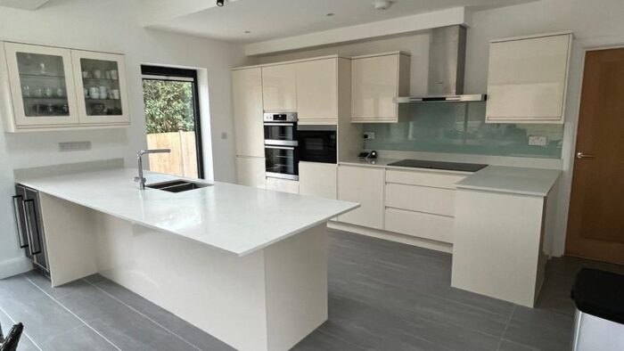 Howdens Modern Handleless Kitchen & Peninsular AEG Neff Appliances Stone Worktops