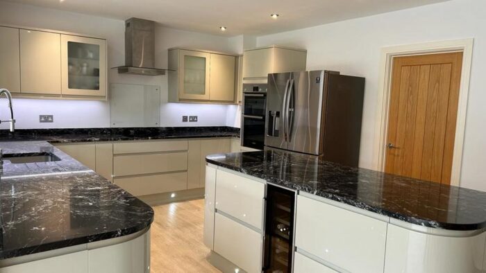 Howdens Ivory Gloss Handless Kitchen & Island - Bosch Appliances - Black Granite Worktops - LED lighting