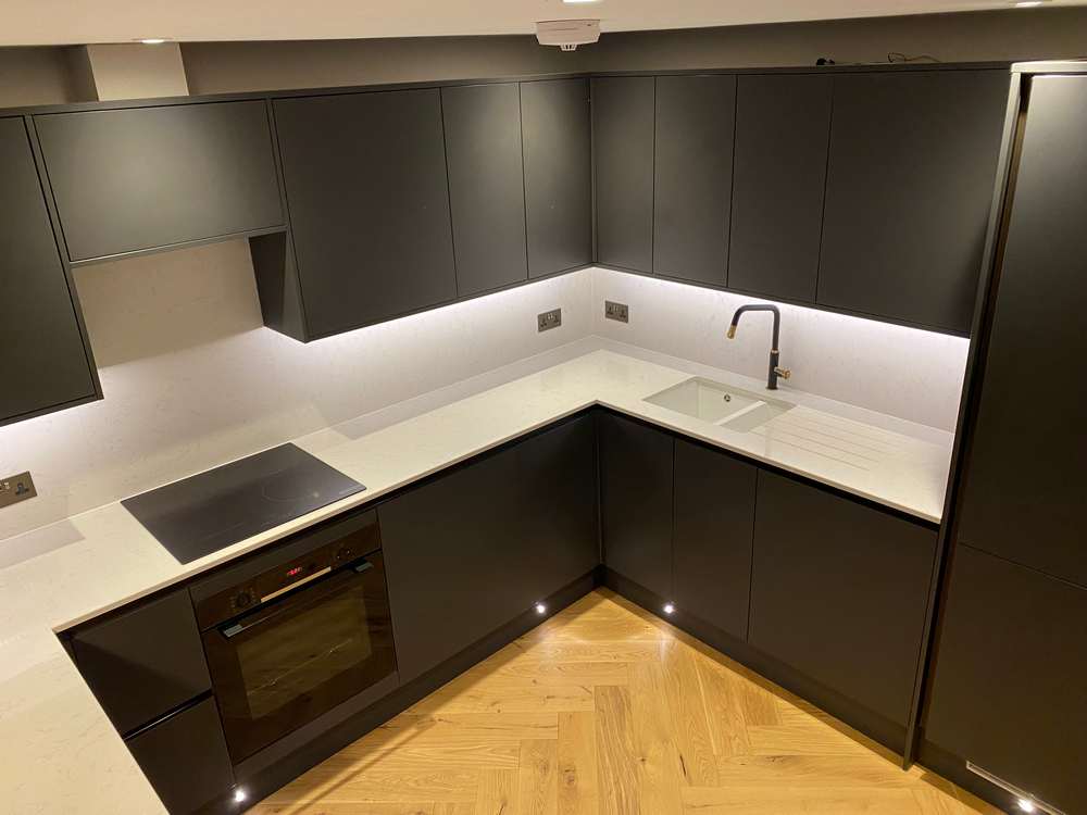 https://usedkitchenhub.com/wp-content/uploads/2023/12/Howdens-Hockley-Charcoal-Super-Matt-Handleless-Kitchen-Peninsular-%E2%80%93-Neff-Bosch-Appliances-Quartz-Worktops-inc-Waterfall-Side-00024.jpg