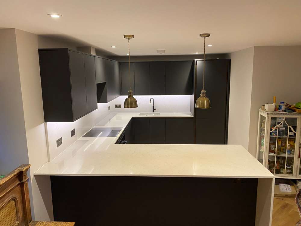 https://usedkitchenhub.com/wp-content/uploads/2023/12/Howdens-Hockley-Charcoal-Super-Matt-Handleless-Kitchen-Peninsular-%E2%80%93-Neff-Bosch-Appliances-Quartz-Worktops-inc-Waterfall-Side-00031.jpg