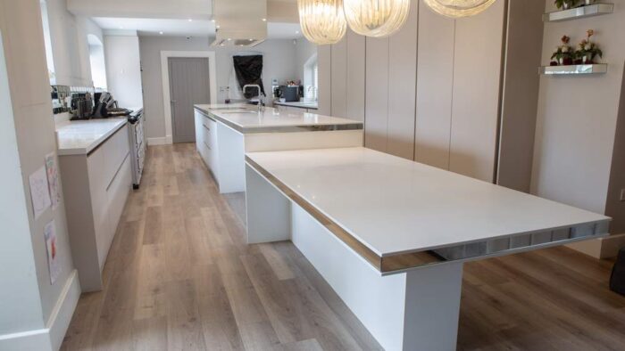 Bespoke Luxury Harrison Collier Stone Grey Kitchen and Large Island with Dining Table – Miele Appliances – White Corian Worktops