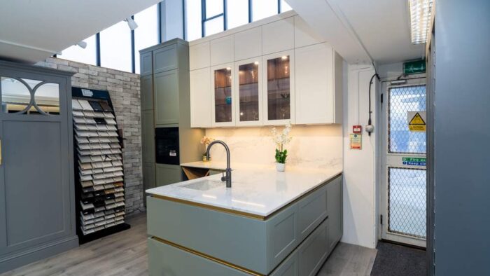 Ex Display Piemont Lacquered Shaker RAL 7033 Sage Green & Magnolia with Gold Channel Handle Kitchen & Peninsular Onyx Grey – Chocolate Oak Carcass – AEG Appliances – Artscut Statuario Eclipse Quartz Worktop