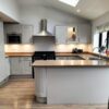 Howdens Burford Stone Grey Shaker Kitchen with Peninsula - Cookmaster Lamona Appliances – American Pecan Laminate Worktops