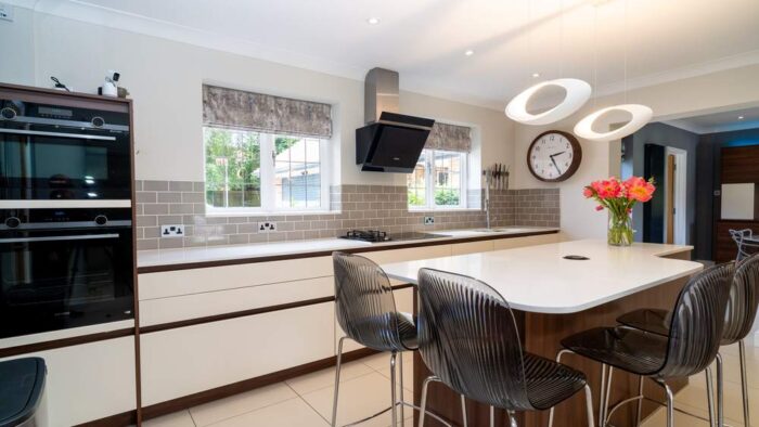 Rotpunkt Handleless Buttercream and Walnut Kitchen with Matching Island and Utility Room – Kuppersbusch Liebherr Caple Appliances - Caesarstone Worktops