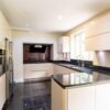 Modern Buttercream Handleless Kitchen with Peninsula – Neff Miele Samsung Appliances – Black Granite Worktops