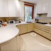 Buttercream and Taupe Handleless Kitchen with Peninsula and Utility Room – Siemens Miele Neff Appliances – Corian Worktops