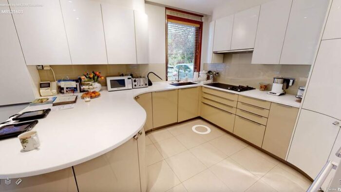 Buttercream and Taupe Handleless Kitchen with Peninsula and Utility Room – Siemens Miele Neff Appliances – Corian Worktops