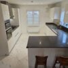 Commodore White Gloss Handless Kitchen with Peninsula and Utility Room – AEG Appliances – Silestone Worktops