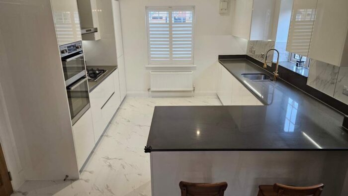 Commodore White Gloss Handless Kitchen with Peninsula and Utility Room – AEG Appliances – Silestone Worktops