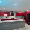 Young Modern Red Gloss with Black Handled Kitchen with Peninsula – Neff CDA LG Appliances – White Krion Worktops