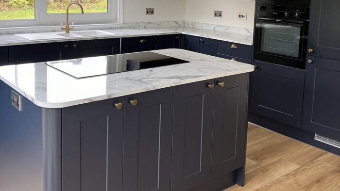 Young Howdens Dark Blue Shaker with Brushed Brass Handled Kitchen and Matching Island – Neff Lamona Appliances - Marble Effect Quartz Worktops