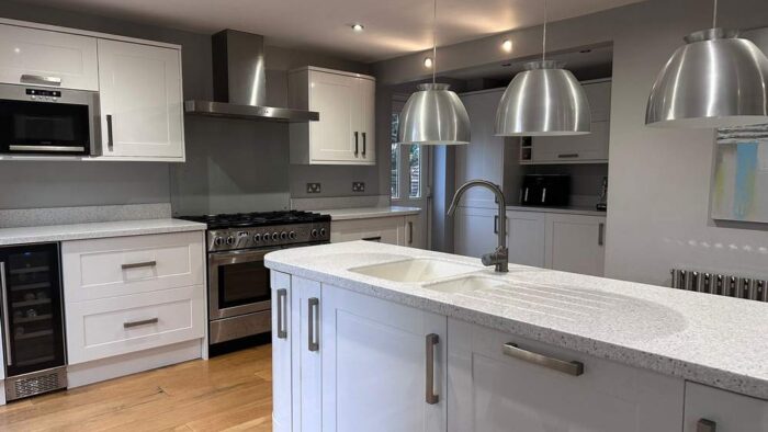 Howdens White Shaker Kitchen including Island with Glass Breakfast Bar – Rangemaster Lamona Hotpoint Appliances – Corian Worktops