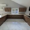 Bespoke Modern Walnut Look and Beige Handled Kitchen including Peninsula with Breakfast Bar and Utility Room – Bosch Caple Appliances – Sandy Coloured Corian Worktops