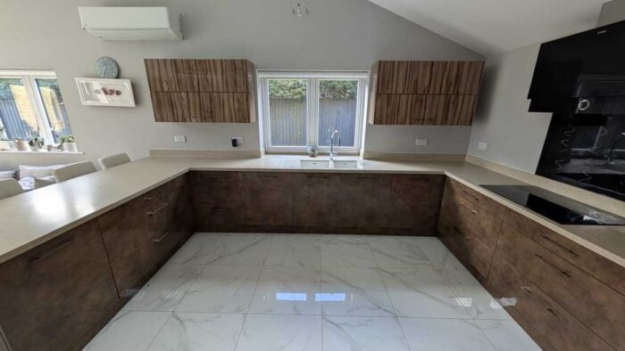 Bespoke Modern Walnut Look and Beige Handled Kitchen including Peninsula with Breakfast Bar and Utility Room – Bosch Caple Appliances – Sandy Coloured Corian Worktops