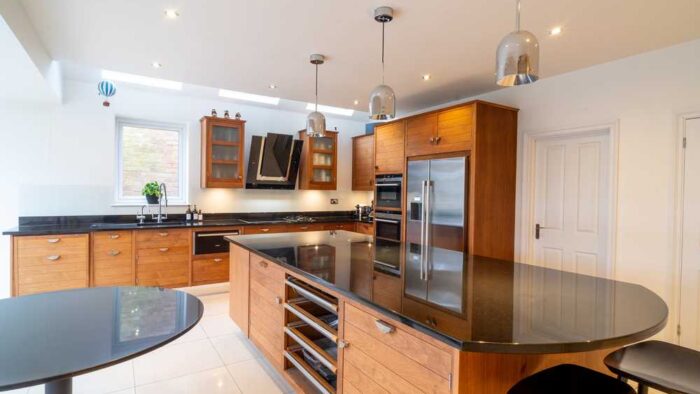 Luxury Smallbone Walnut & Silver Stained Slatted Kitchen with Matching Island - Traditional Satin Chrome Butt Hinges – Siemens Elica Appliances – Black Granite Worktops