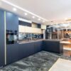 Ex Display Beeck Idealxt Anti Fingerprint Fenix Black Door with Gold Trim Kitchen with Peninsula and Dining Table – 1810 Appliances – Vanilla Noir Caesarstone Quartz Worktops