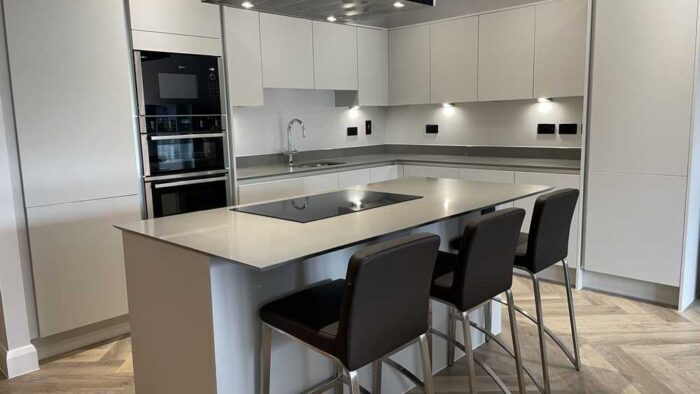 Young Dove Grey Modern Slab Kitchen and Matching Island – Neff Indesit Appliances – Silestone Worktops