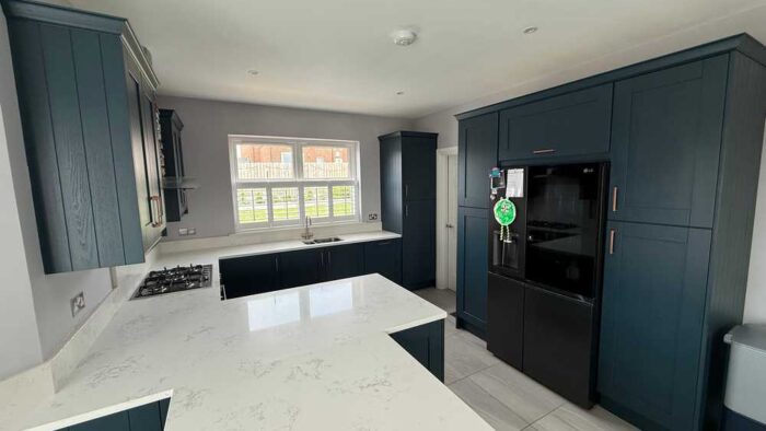 Young Blue Shaker Kitchen with Peninsula and Breakfast Table – Candy LG Appliances – Quartz Worktops